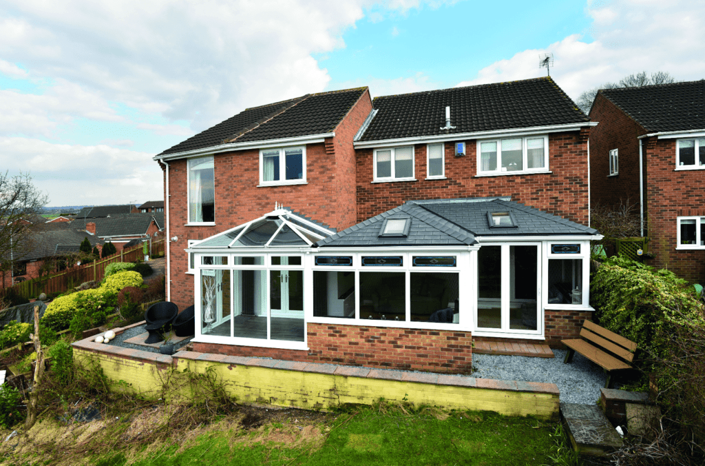 Brick house with a white conservatory and a modern rear extension featuring large windows.