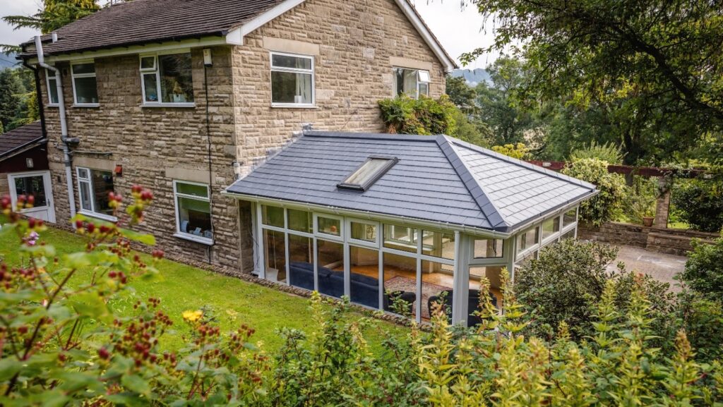 A tiled roof conservatory at the rear of a traditional brick house